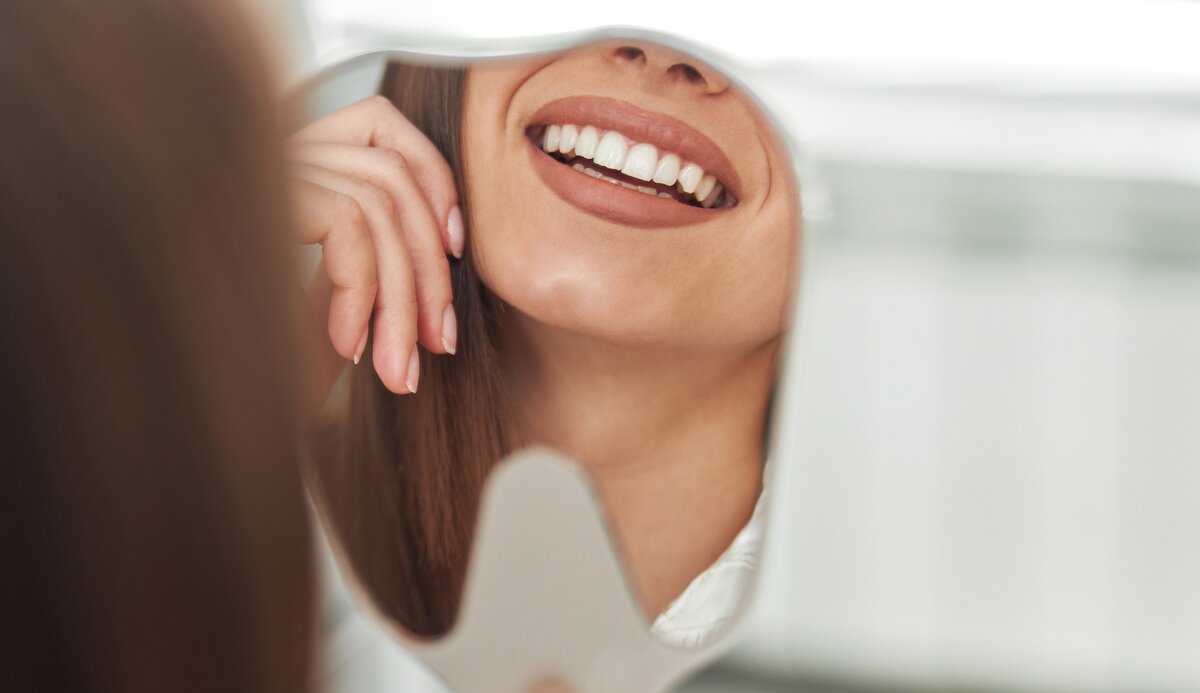 Mulher sorrindo no espelho